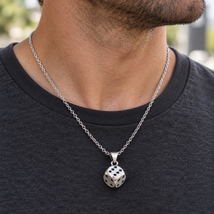 Anchor sterling silver chain worn with a silver dice pendant over a charcoal T-shirt