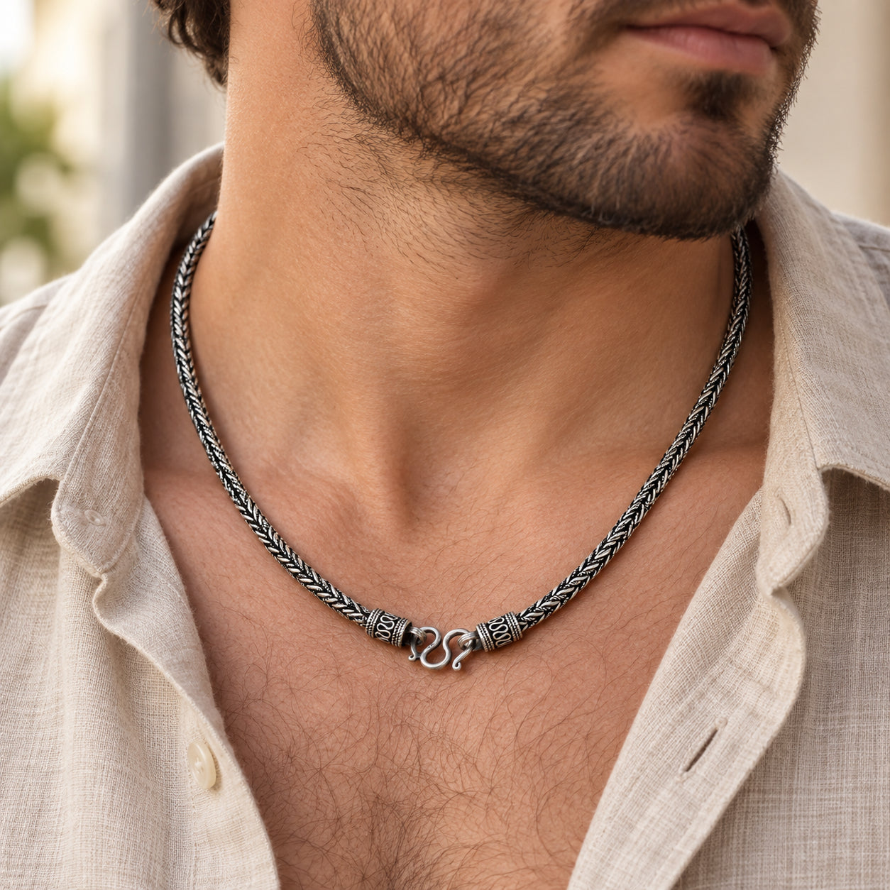 Sterling silver Braid Chain necklace with decorative front clasp worn with an open linen shirt