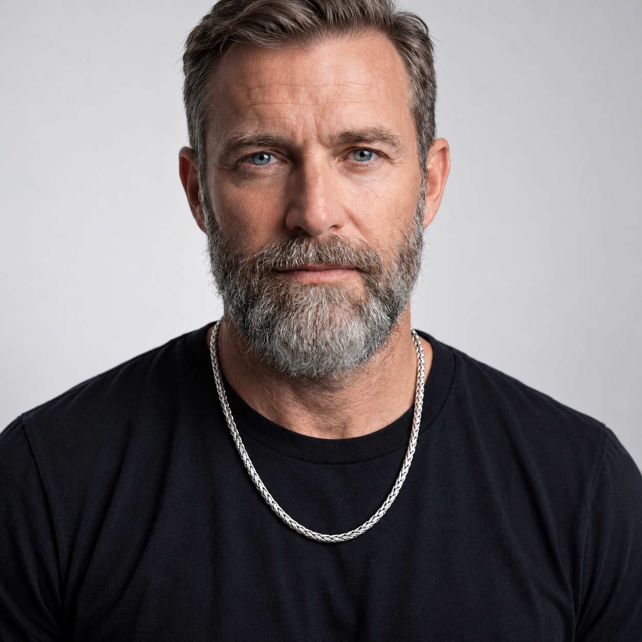 Bearded man wearing a sterling silver Dream Weave necklace over a black shirt