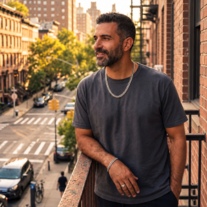 Man wearing a sterling silver Elegant Chain necklace and matching bracelet on a city balcony