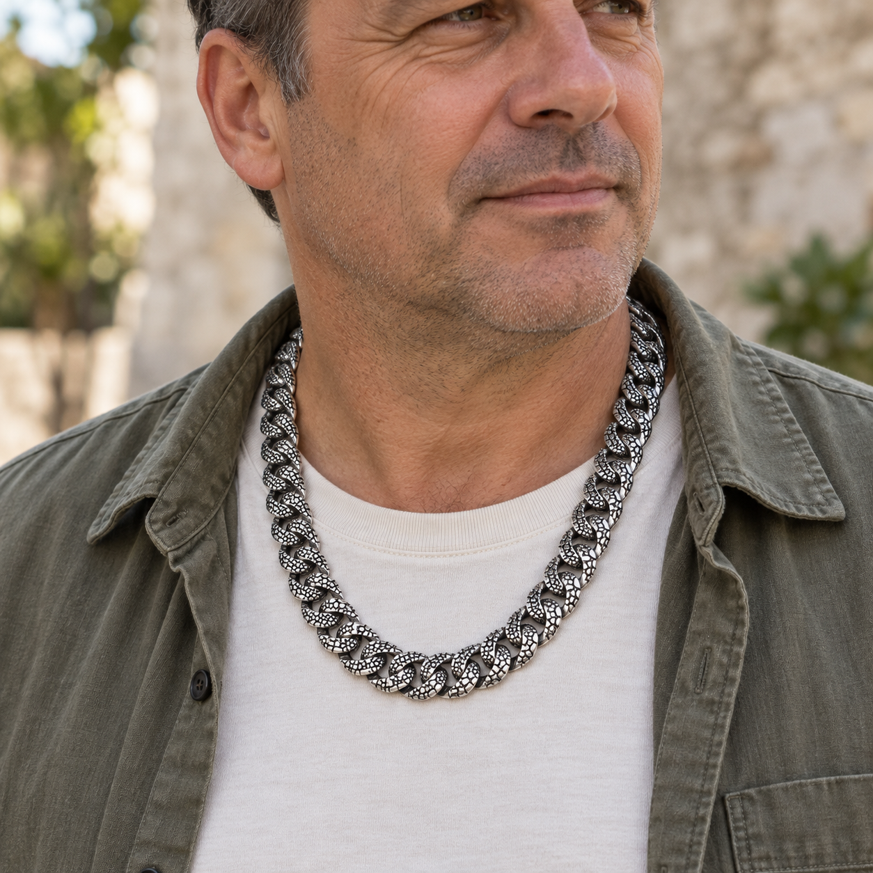 Man wearing a Lizard Skin sterling silver chain with an olive overshirt and white T-shirt