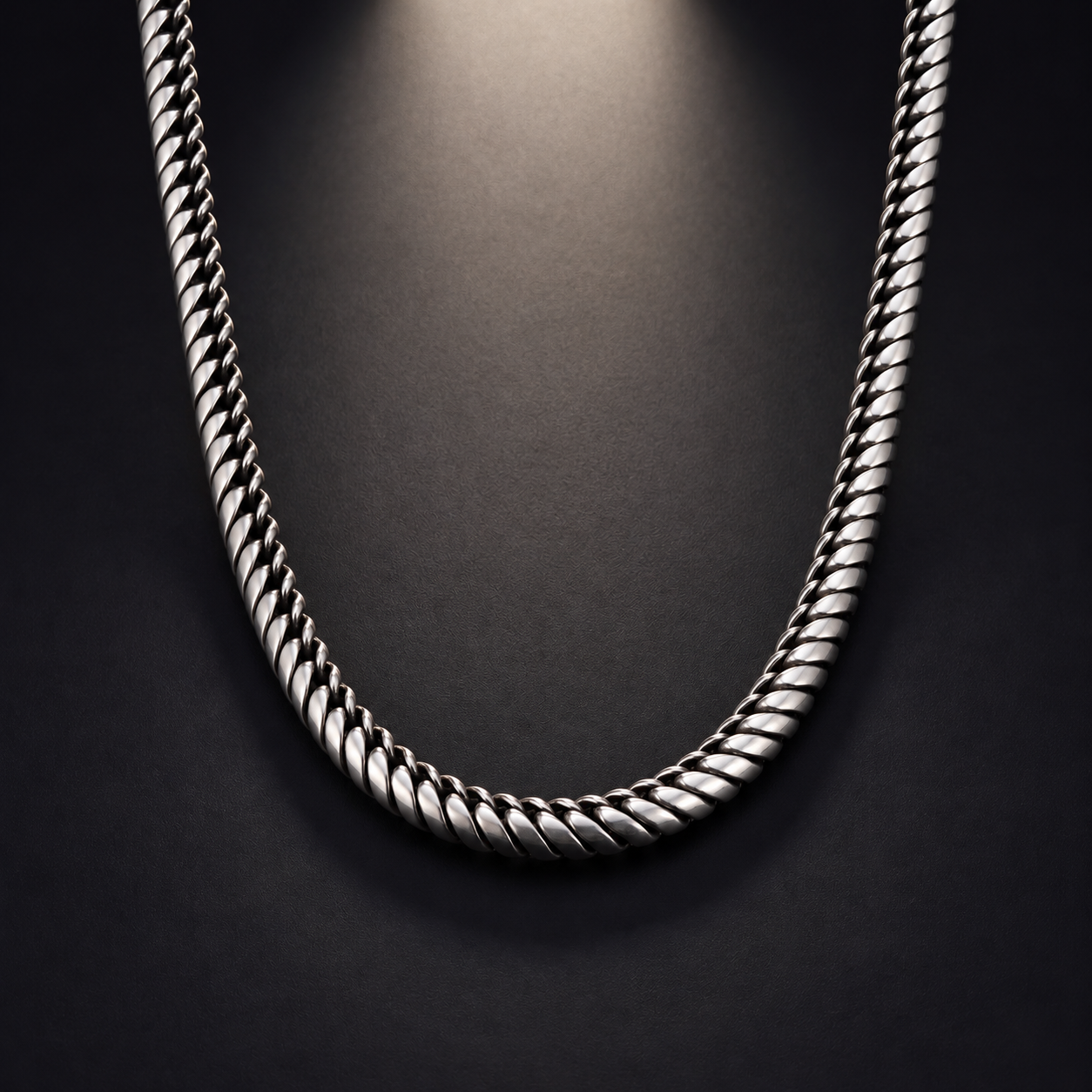 Sterling silver Snake Chain necklace on a dark studio background with overhead lighting