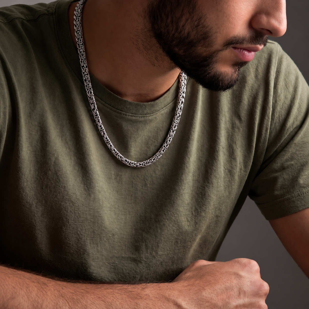 Man wearing a sterling silver Woven Rope Byzantine necklace with an olive green shirt